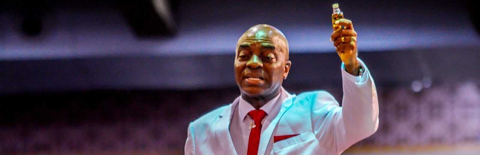 évèque David Oyedepo tenant une bouteille de huile onction